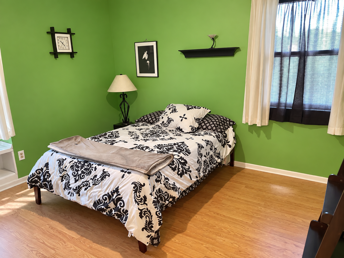 Queen bedroom with green walls and black and white bedding