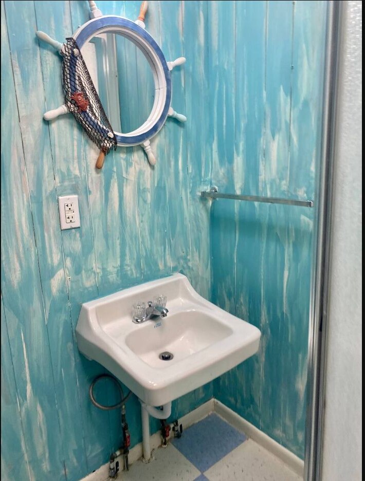 Second bathroom sink with ship wheel mirror