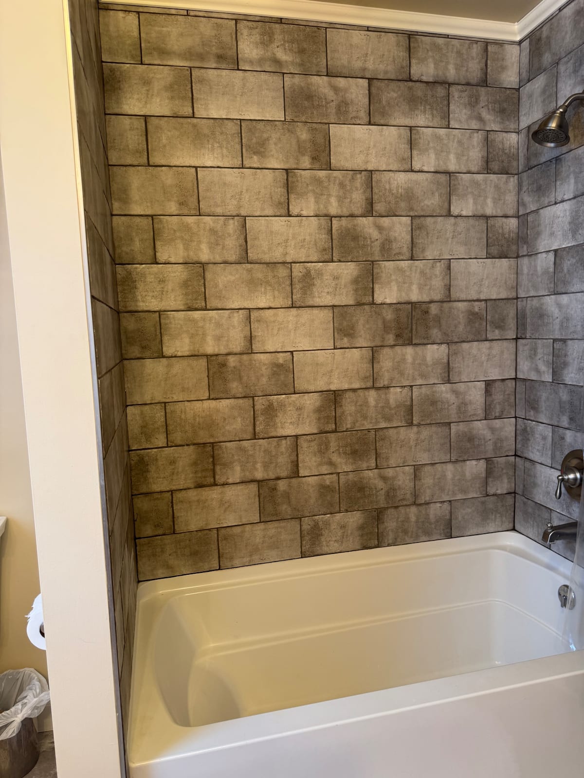 Bathroom bathtub with dark tile surround